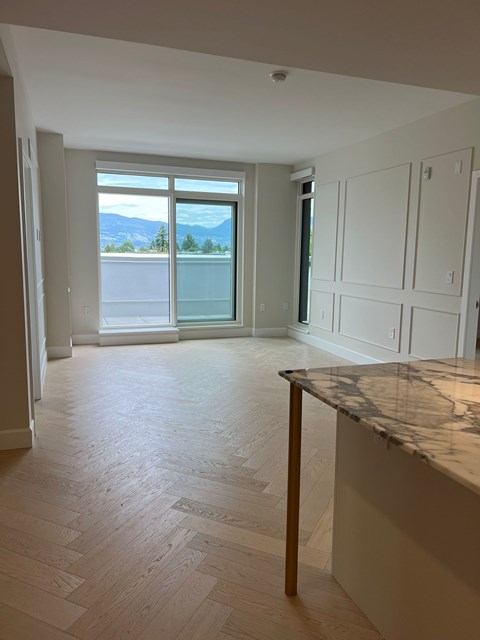 A kitchen with a marble counter top and wooden floors.