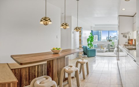 A modern kitchen with a wooden bar and stools.