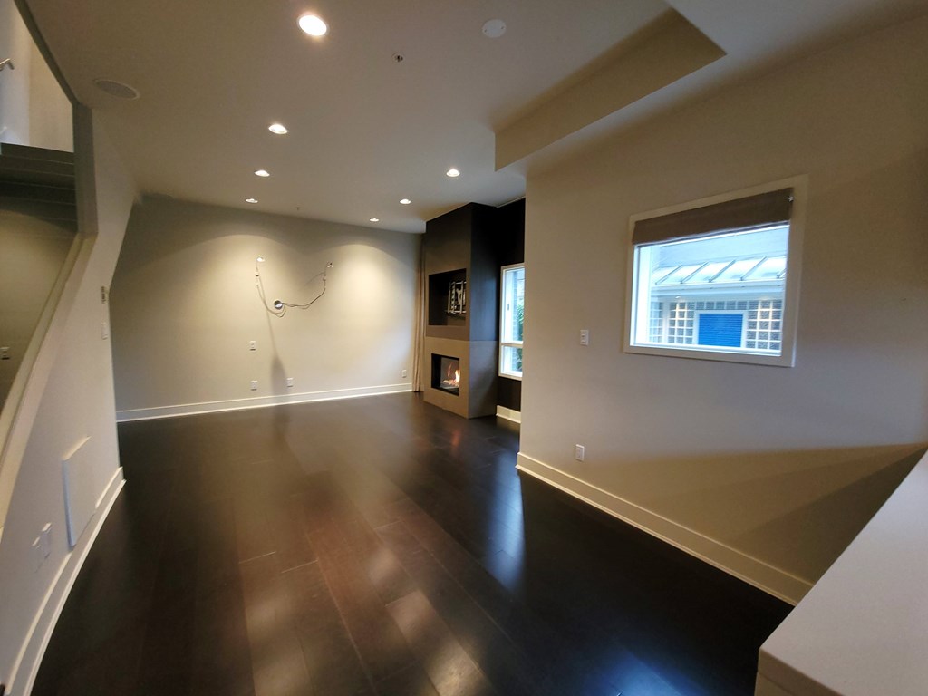 A spacious room with wooden floors and a window.