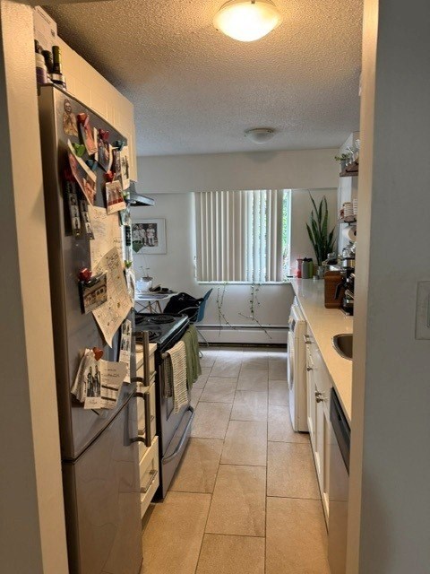 A kitchen with a refrigerator covered in magnets and notes.