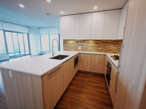 A modern kitchen with wooden cabinets and a white countertop.