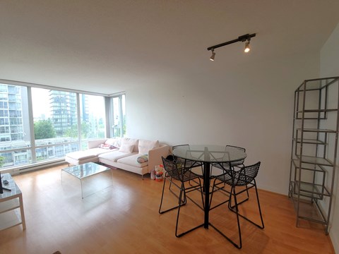 a living room with a table and a couch and a large window
