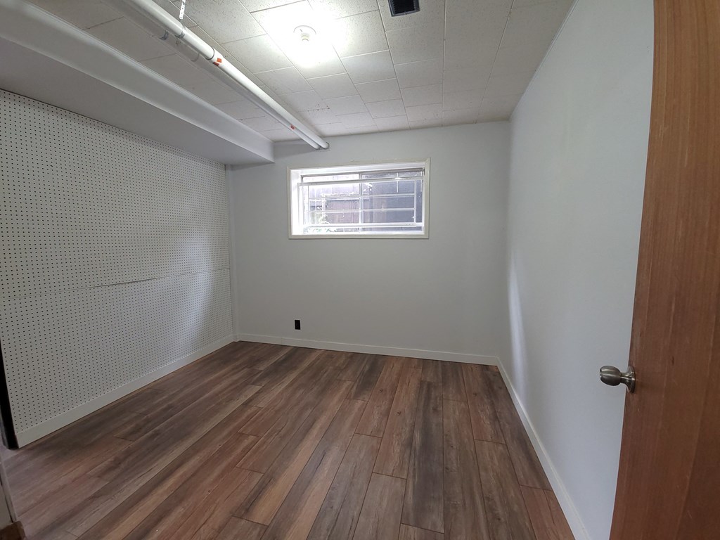an empty room with wooden floors and a window