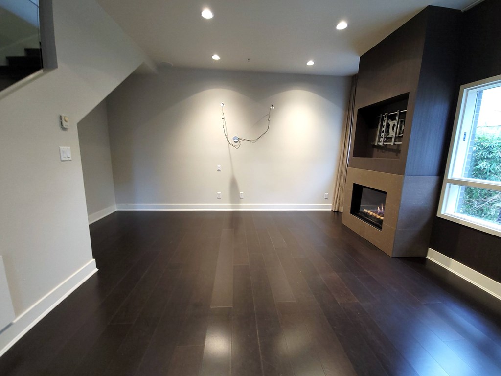 A room with a fireplace and wood flooring.