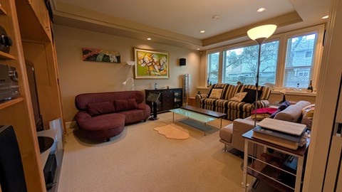 A living room with a red chair and a couch.