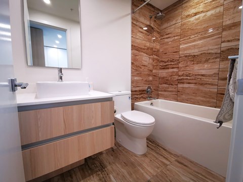 A bathroom with a wooden wall and a white toilet.