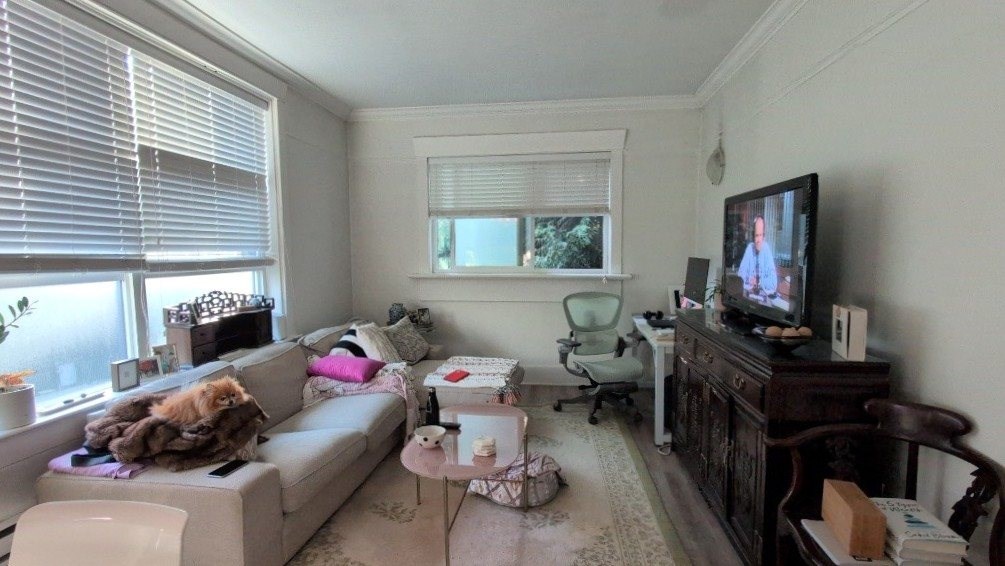 A living room with a couch, a chair, a television, and a coffee table.