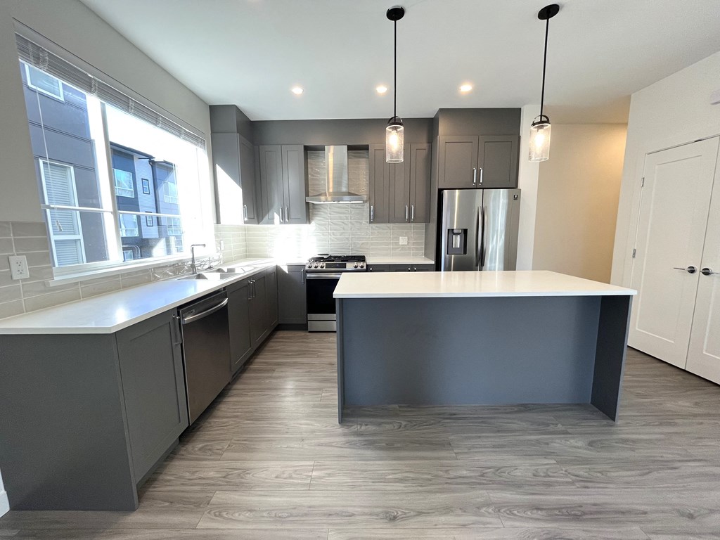 a renovated kitchen with gray cabinets and a white counter top