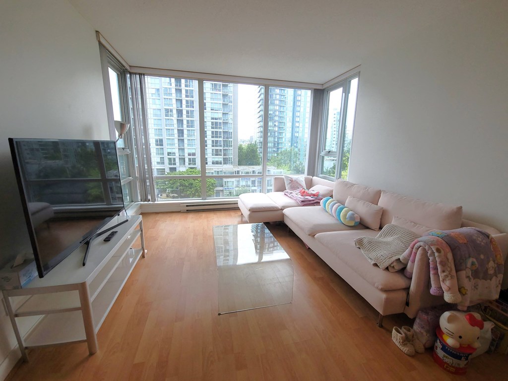 a living room with a couch and a tv and a window