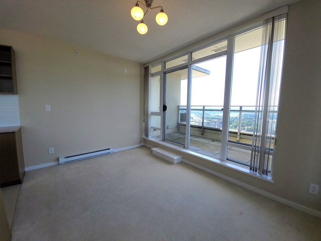 the living room of an empty apartment with large windows