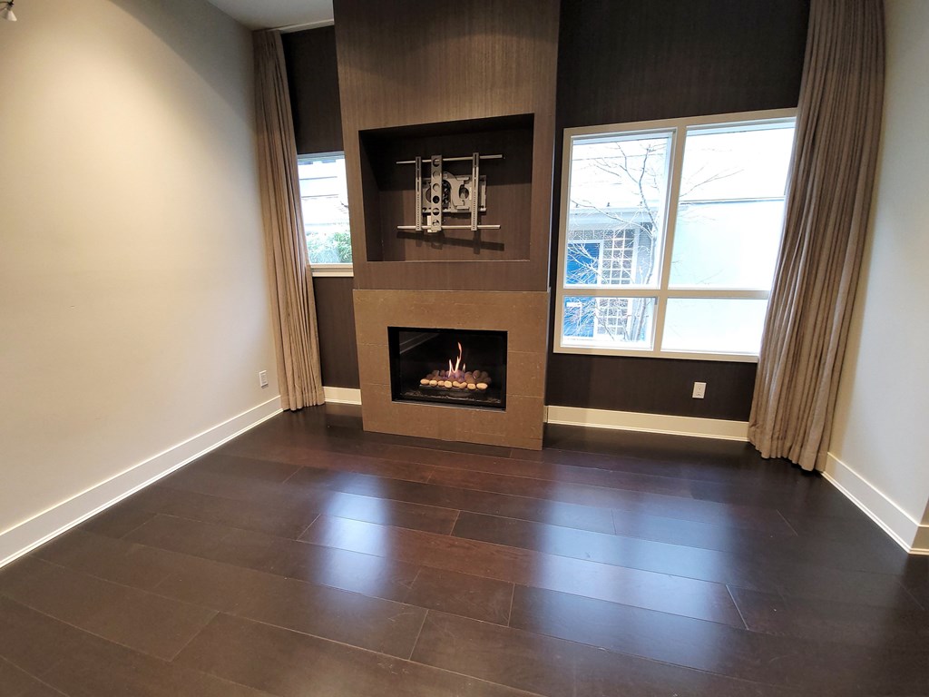 A modern living room with a fireplace and a flat screen TV mounted above it.