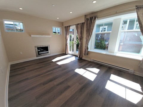 A living room with a fireplace and large windows.
