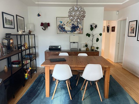 A dining room with a wooden table and chairs.