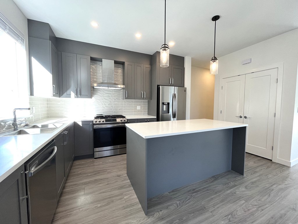 a kitchen with gray cabinets and a white counter top