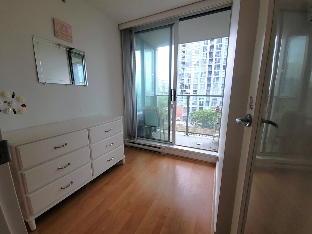 a bedroom with a large window and a door to a balcony