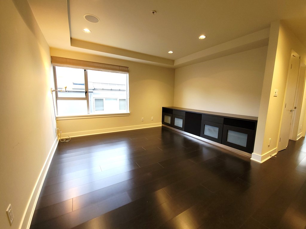 A room with a window and a row of black shelves.