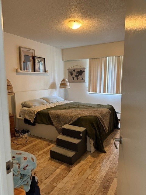 A bedroom with a bed, a staircase, and a picture on the wall.