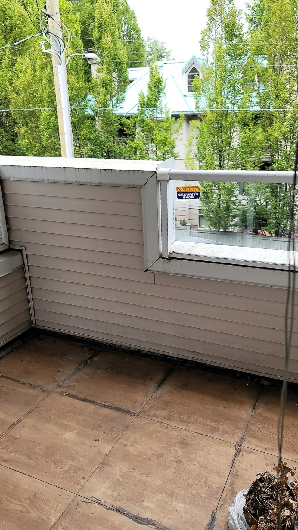 A small window on a house with a view of a blue house in the background.
