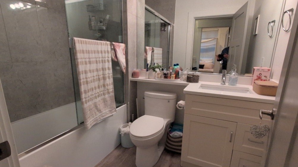 A bathroom with a toilet, sink, and mirror.