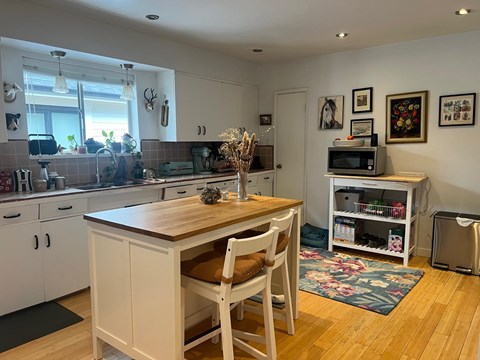 A kitchen with a wooden table and chairs.
