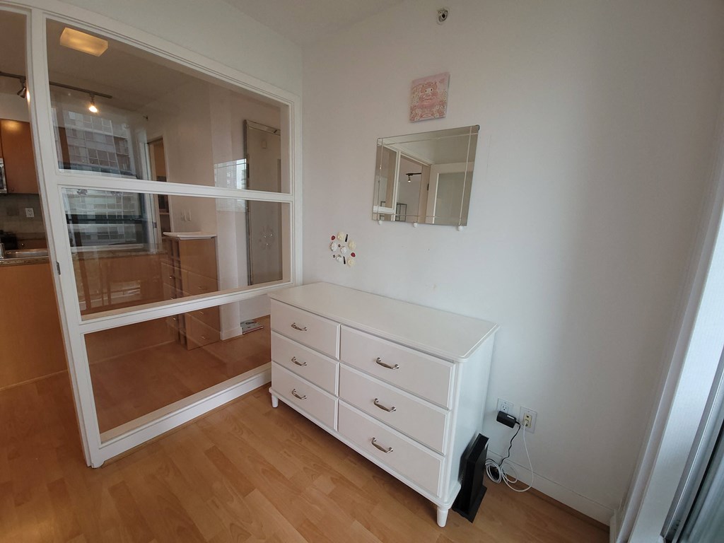 a bedroom with a dresser and a mirror on the wall