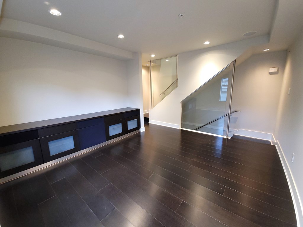 A room with a wooden floor and a glass staircase.