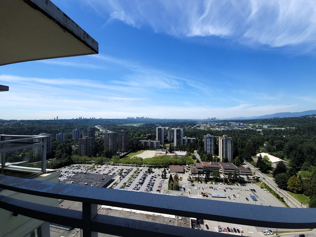 a balcony with a view of a parking lot and the city