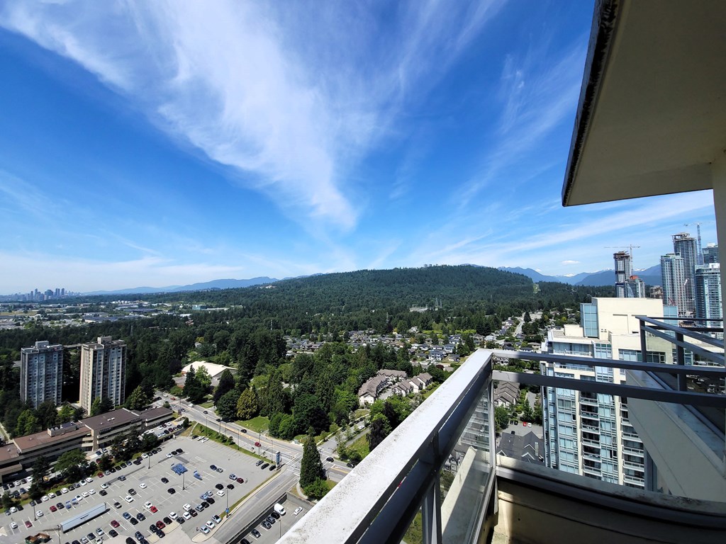 a balcony with a view of a city and a mountain