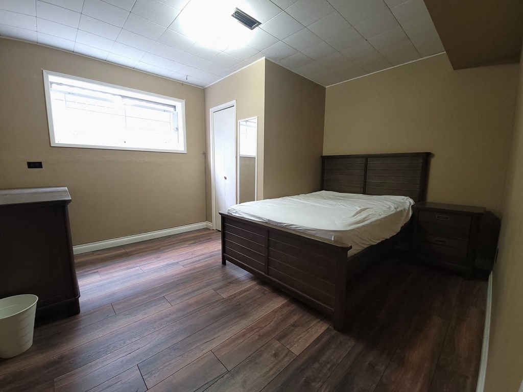 an empty bedroom with a bed and a window