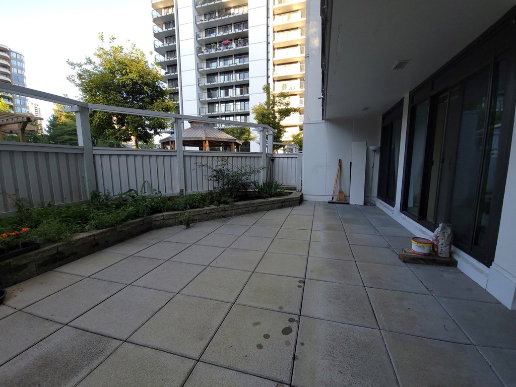 a balcony with a tiled floor and a white fence