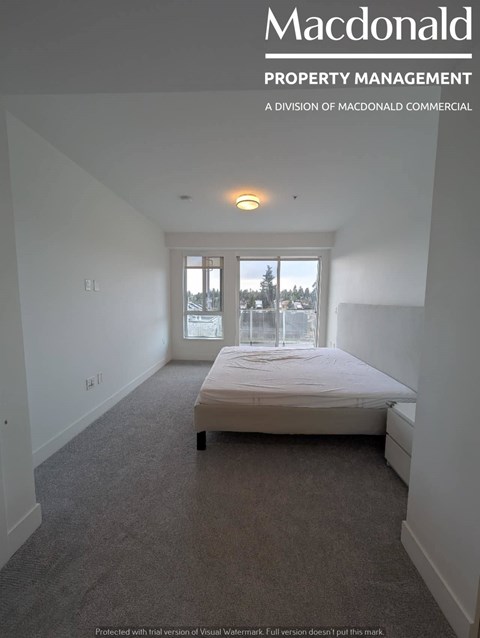 A MacDonald Property Management brochure featuring a bedroom with a large bed and a view of trees outside the window.
