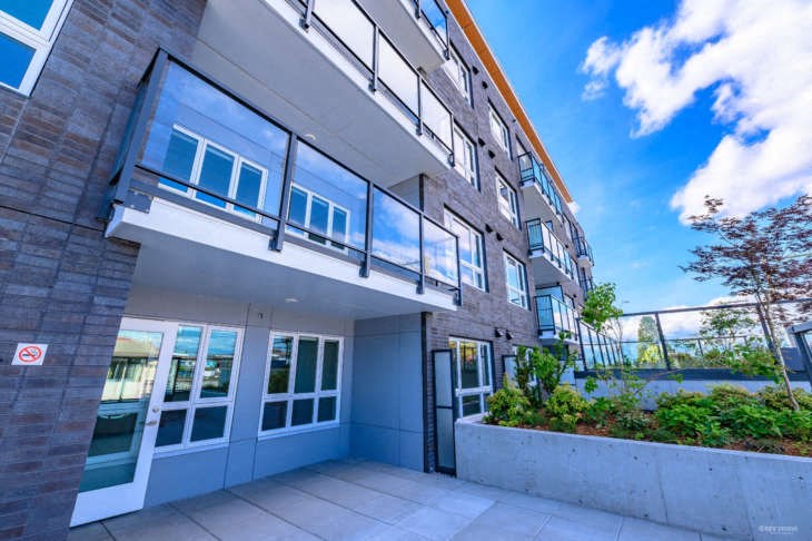 a large apartment building with a patio and a blue sky