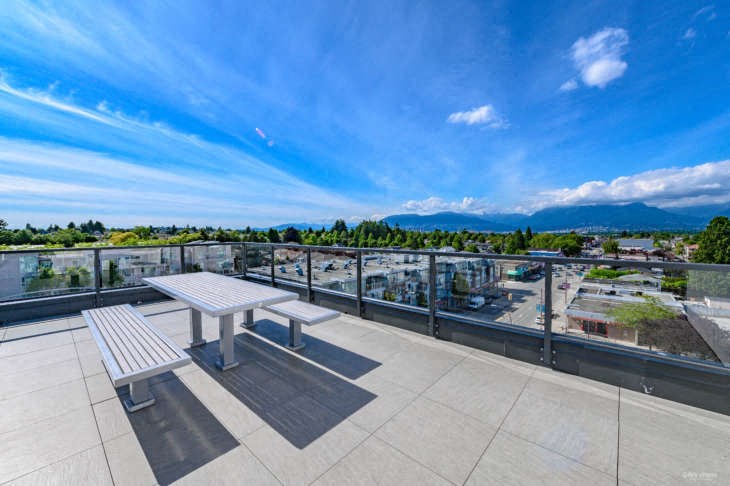 a picnic table on a balcony overlooking the city and mountains