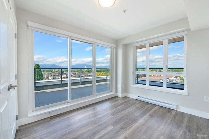 a living room with a view of a balcony and windows