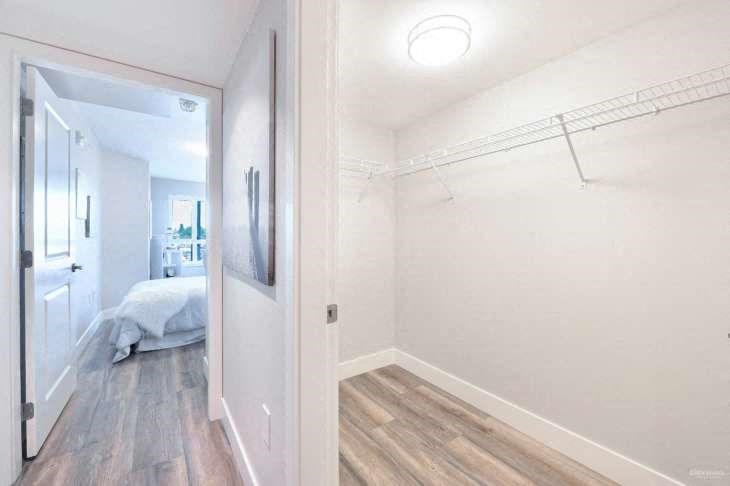 a bedroom with a closet and a mirror on the wall