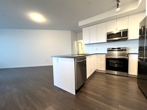A kitchen with white cabinets and stainless steel appliances.
