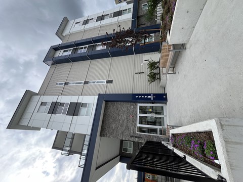 A modern building with a grey exterior and a black awning.