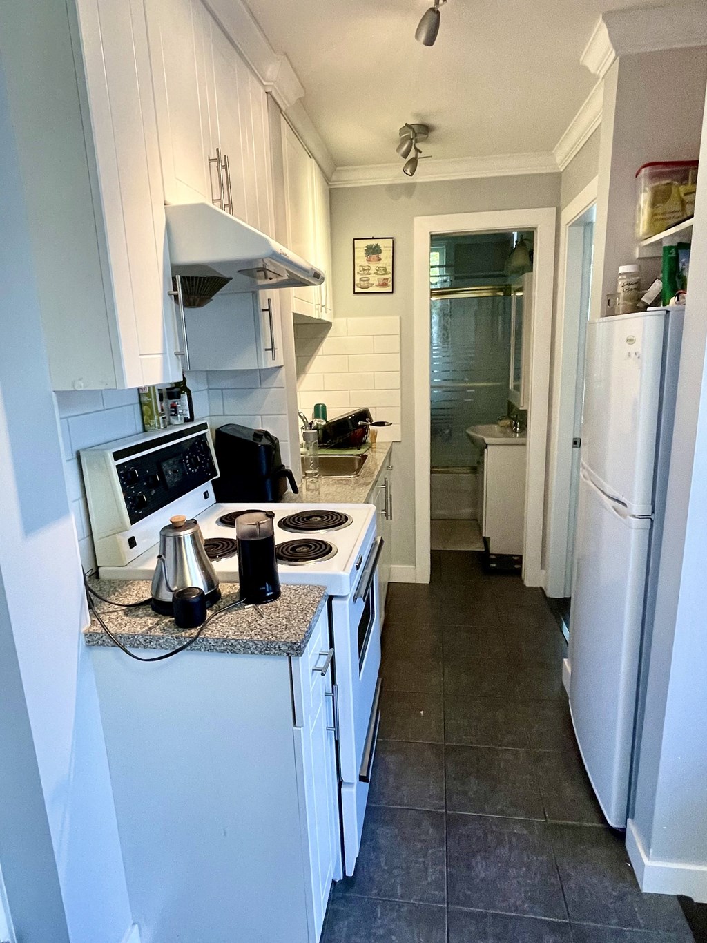 a small kitchen with white appliances and white cabinets