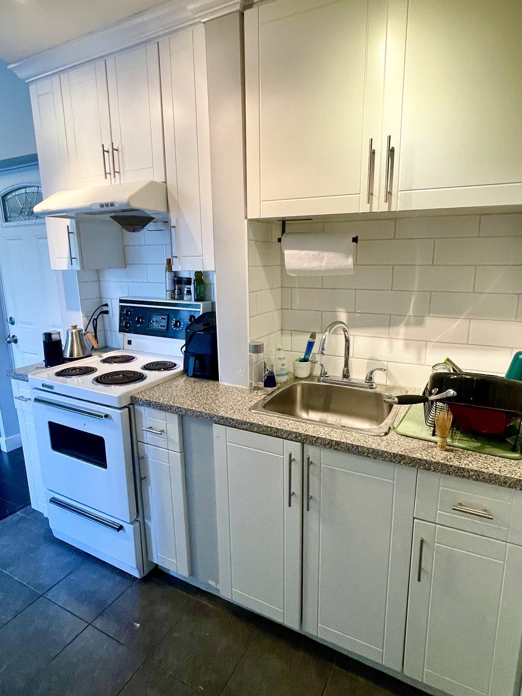 a kitchen with white cabinets and a white stove top oven