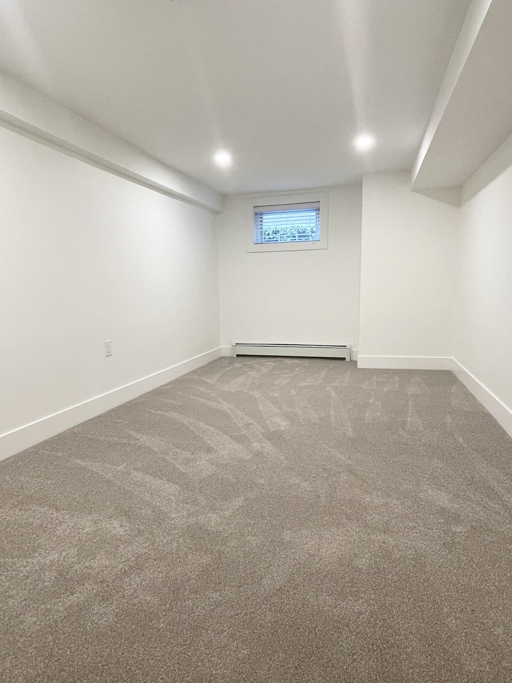 an empty room with carpet and a window