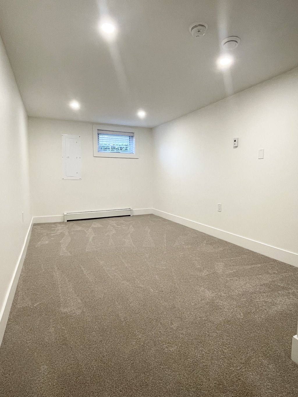 an empty room with carpet and a window