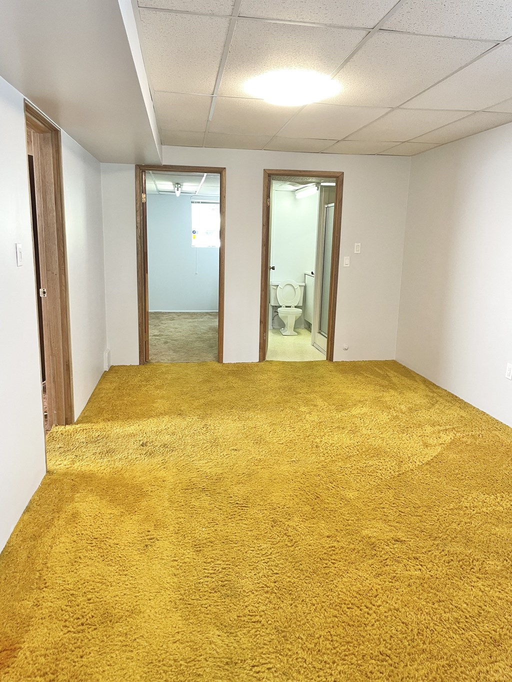 an empty room with a yellow carpet in the middle of it