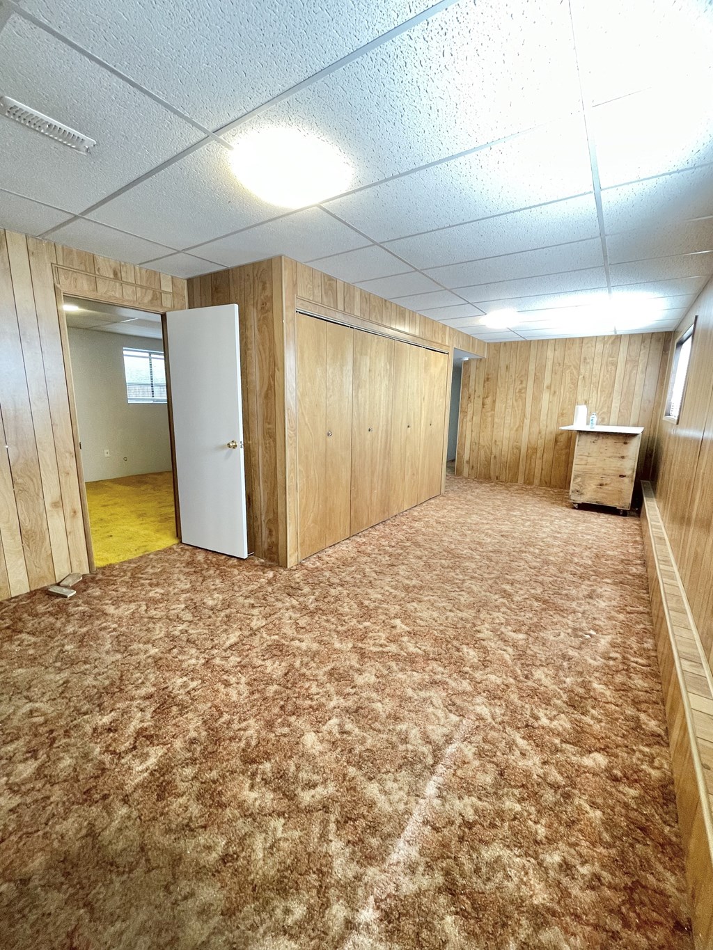 a room with wood paneled walls and a carpeted floor