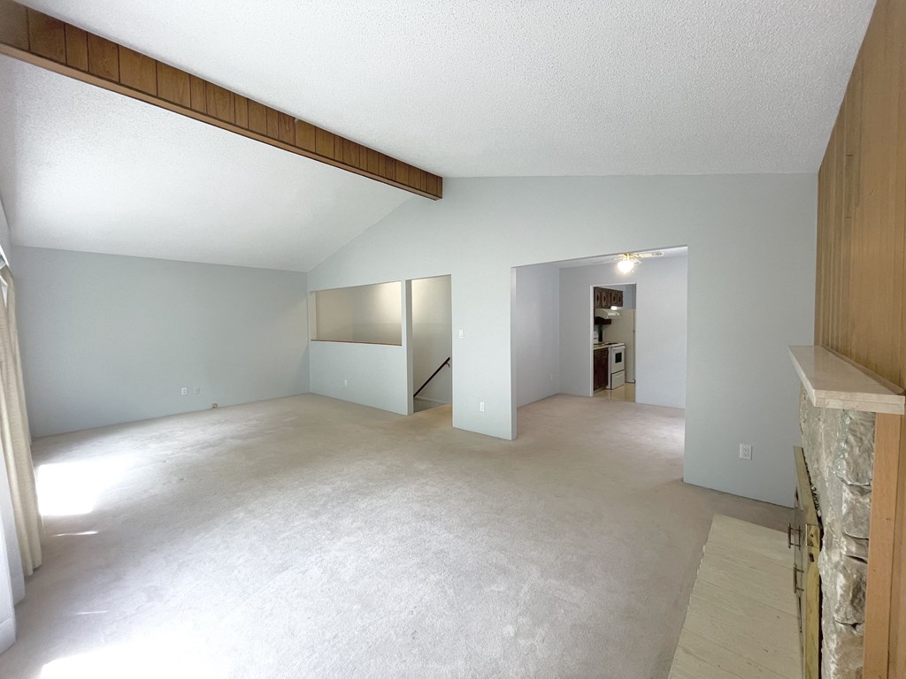 the living room and dining room of an empty house with white carpet and white walls