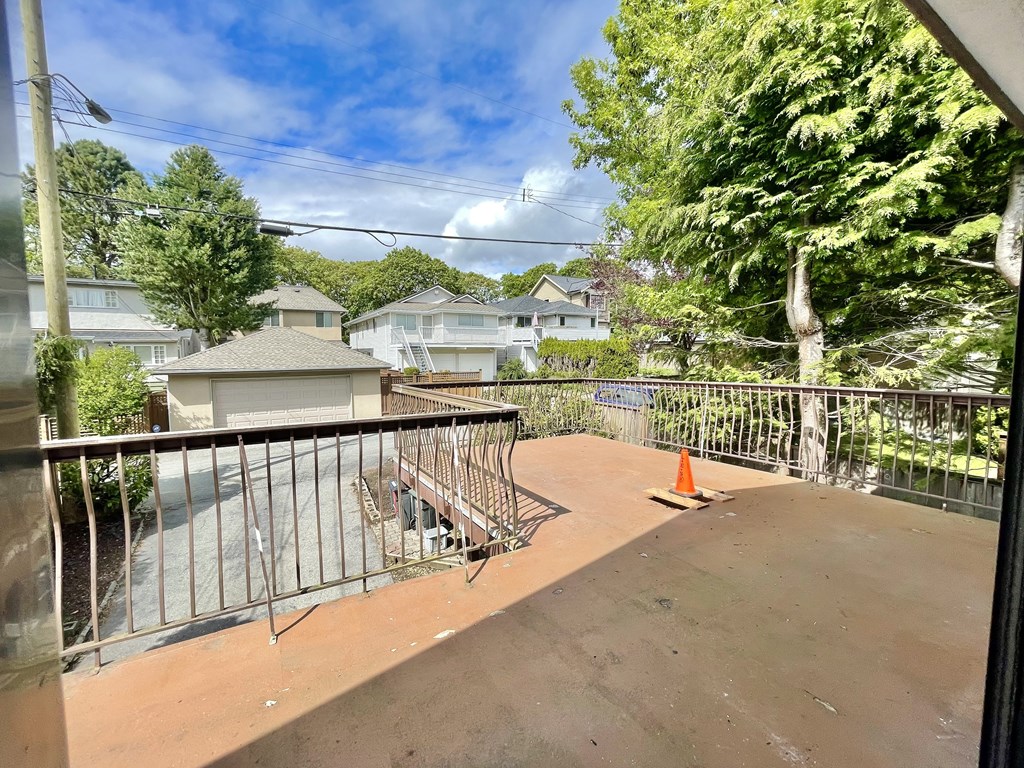 the deck of a house with a fence and a street in the background