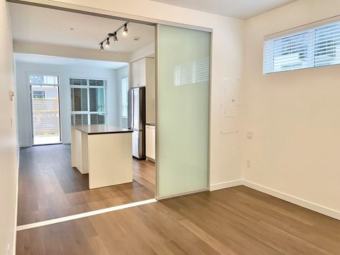 A kitchen with a refrigerator, sink, and cabinets.