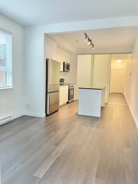 A kitchen with a refrigerator, microwave, and oven.