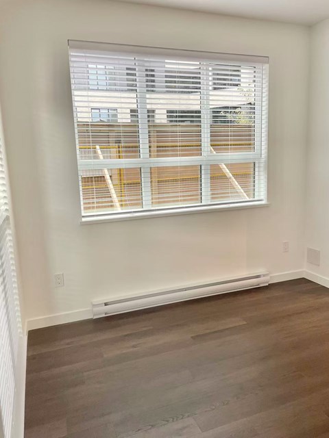 A room with a window covered in blinds.