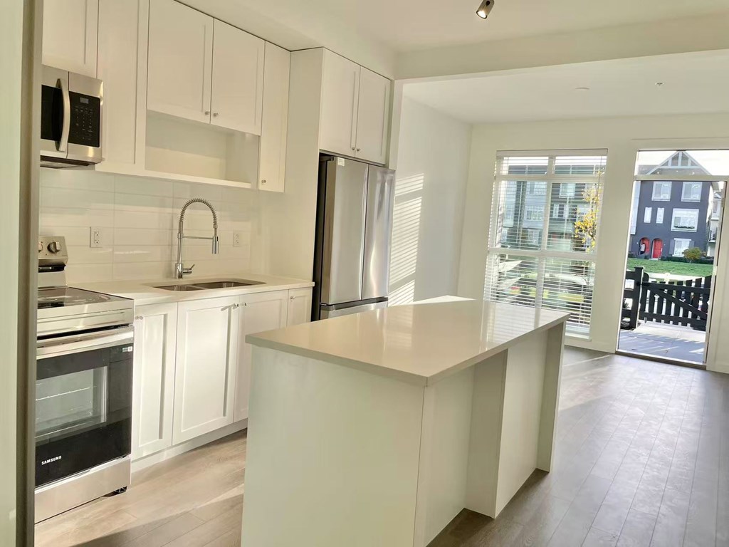 A kitchen with white cabinets and a large island.