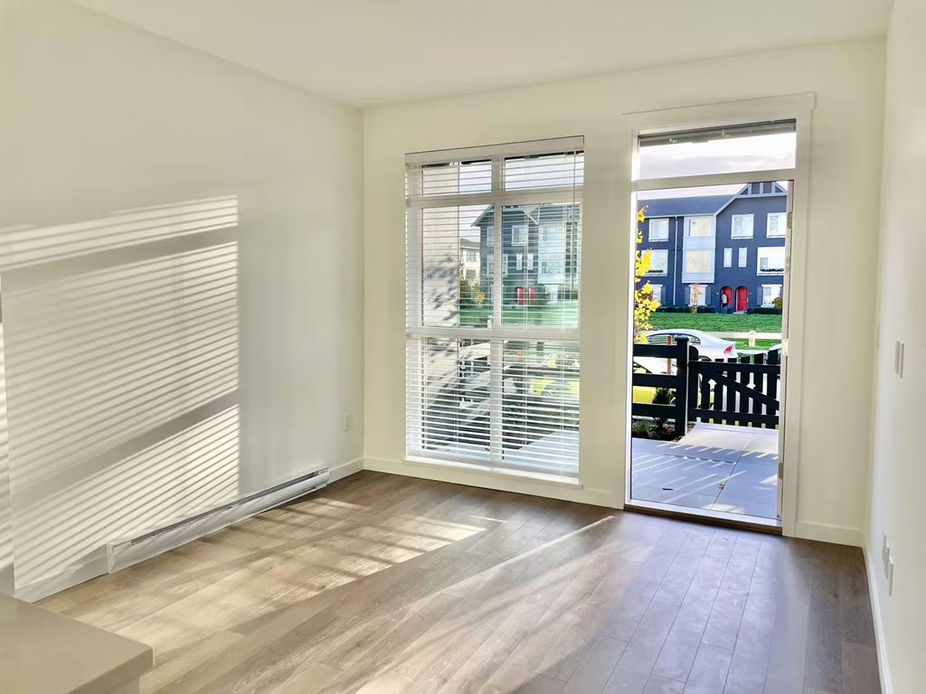 A room with a sliding glass door leading to a backyard.